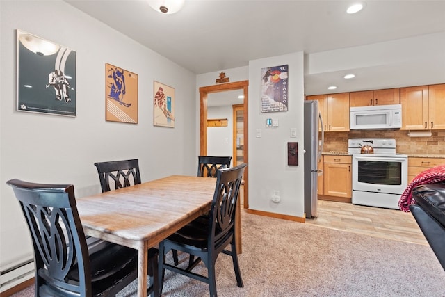 dining room featuring baseboard heating and light colored carpet