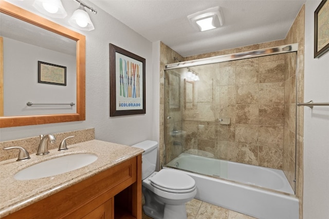 full bathroom featuring tile patterned flooring, bath / shower combo with glass door, a textured ceiling, toilet, and vanity