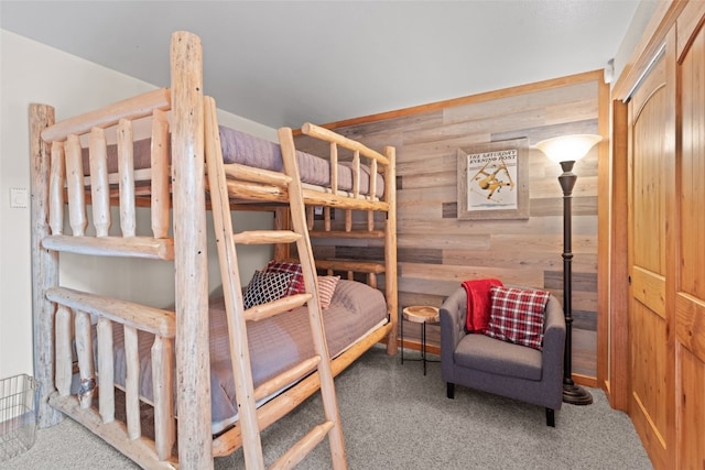 bedroom featuring carpet and wood walls