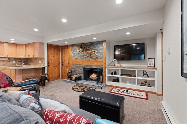 living room featuring baseboard heating, light carpet, and a fireplace