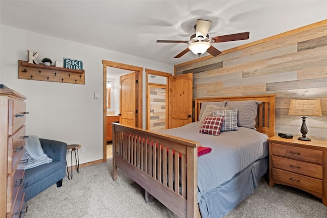 bedroom with light colored carpet, ceiling fan, and wood walls