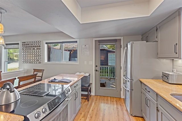 kitchen with range, light hardwood / wood-style floors, pendant lighting, and gray cabinetry