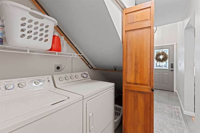 clothes washing area featuring light tile patterned flooring and washer and dryer