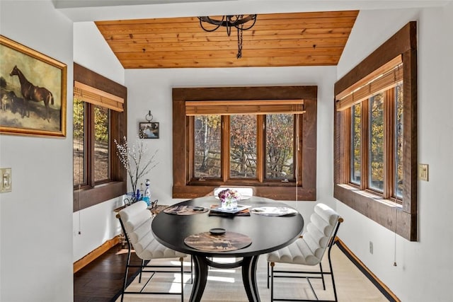 dining space with wood ceiling, vaulted ceiling, and light wood-type flooring