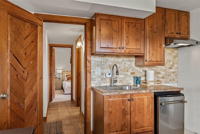 kitchen with decorative backsplash, sink, and ventilation hood