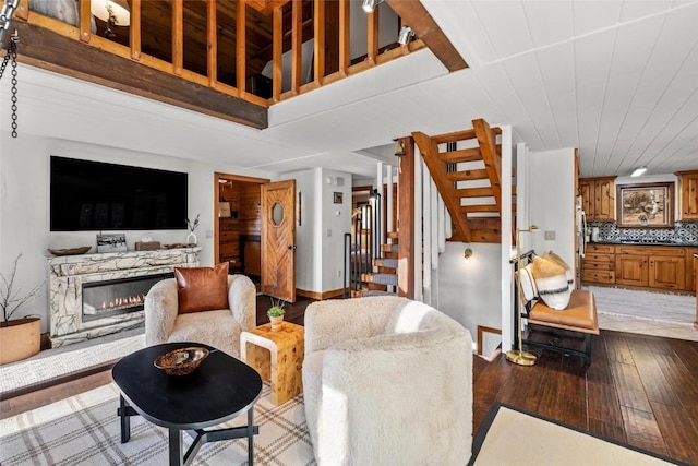 living room with a high end fireplace and light hardwood / wood-style flooring