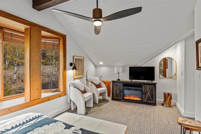 living room with a fireplace, ceiling fan, plenty of natural light, and lofted ceiling with beams