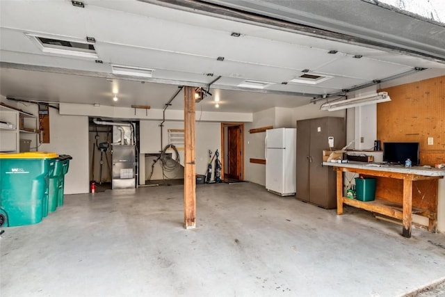 garage with a workshop area and white refrigerator