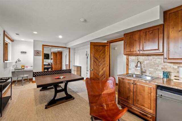 kitchen featuring tasteful backsplash, stainless steel dishwasher, light colored carpet, and sink