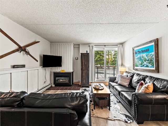 living room with wood-type flooring, a textured ceiling, and a baseboard radiator