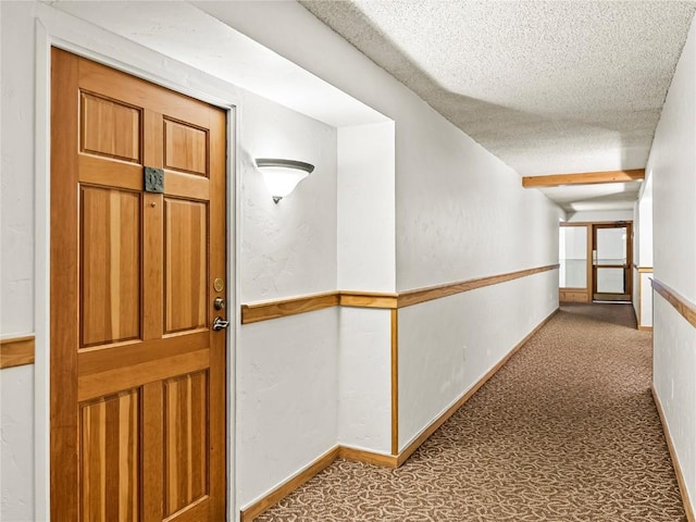 hall featuring light colored carpet and a textured ceiling