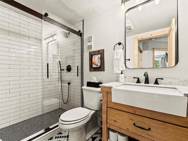 bathroom featuring vanity, a textured ceiling, toilet, and walk in shower