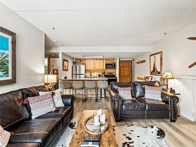 living room featuring light hardwood / wood-style floors and a textured ceiling