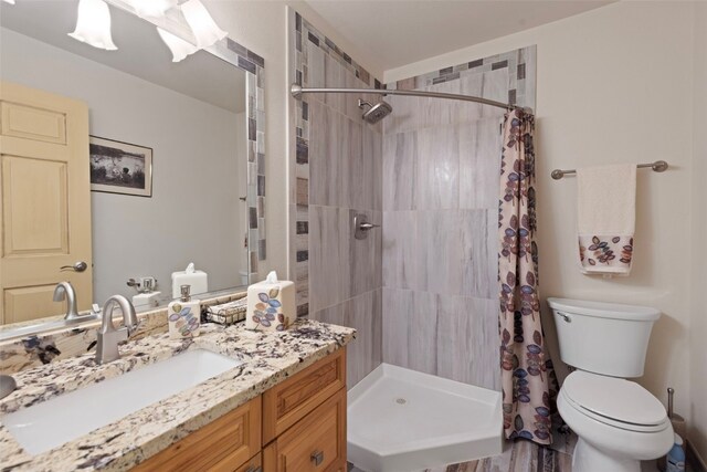 bathroom featuring a shower with shower curtain, vanity, and toilet