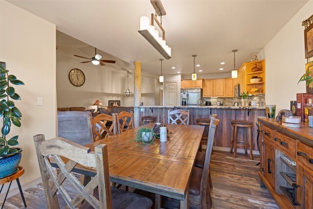 dining space with ceiling fan and dark wood-type flooring