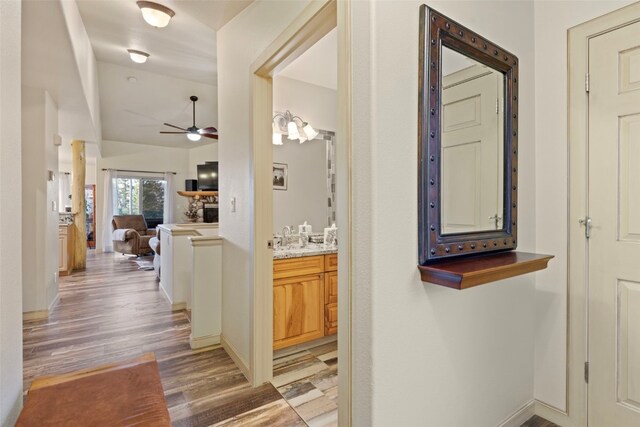 hall with light hardwood / wood-style flooring and sink