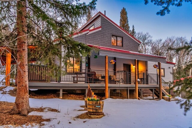 view of snow covered back of property