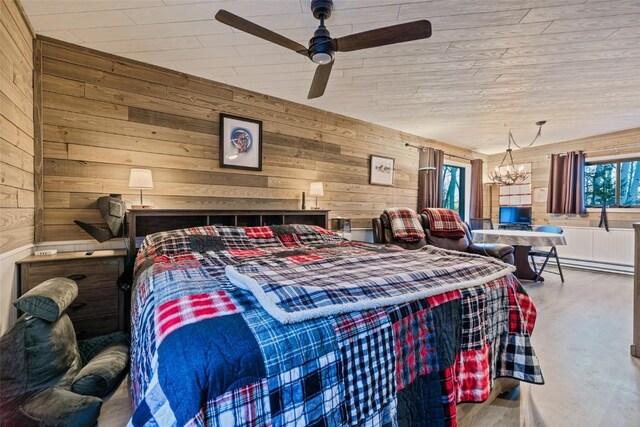 bedroom featuring ceiling fan with notable chandelier, wood walls, and a baseboard radiator