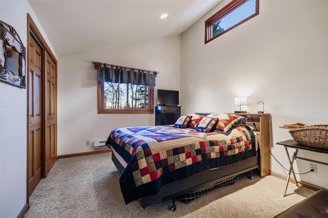 carpeted bedroom with a closet and lofted ceiling