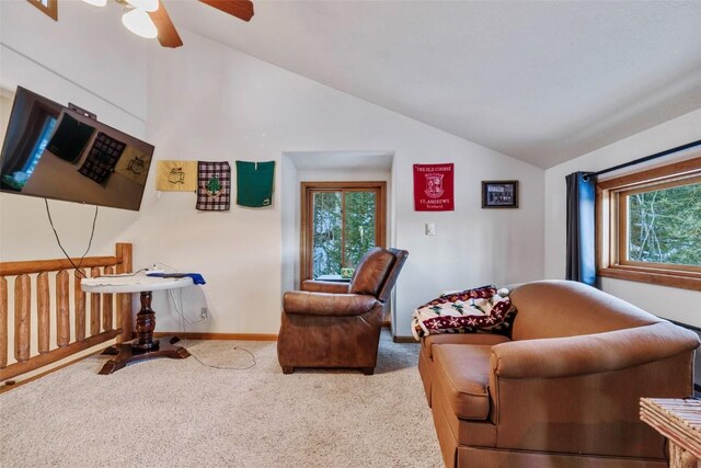 living area featuring carpet flooring, ceiling fan, a healthy amount of sunlight, and lofted ceiling