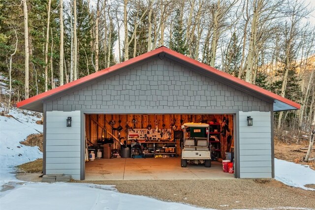 snow covered structure with a garage