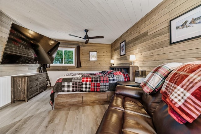 bedroom with ceiling fan, wood walls, light wood-type flooring, and wood ceiling