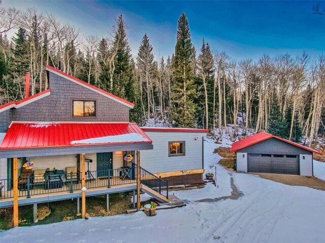 view of front of house with a garage and an outbuilding