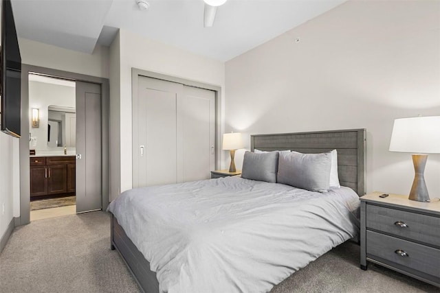 carpeted bedroom featuring connected bathroom, a closet, and ceiling fan