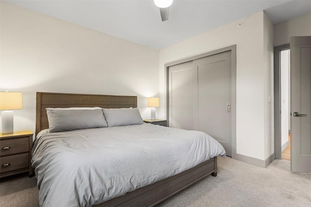 carpeted bedroom with ceiling fan and a closet