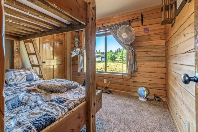 bedroom featuring carpet floors and wood walls