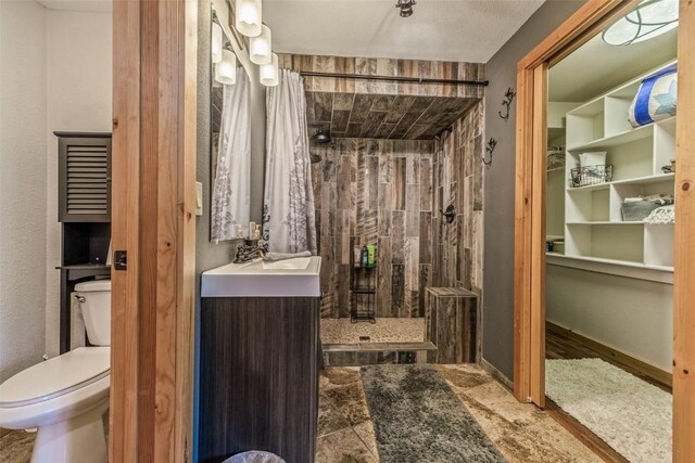 full bath with tiled shower, toilet, and vanity