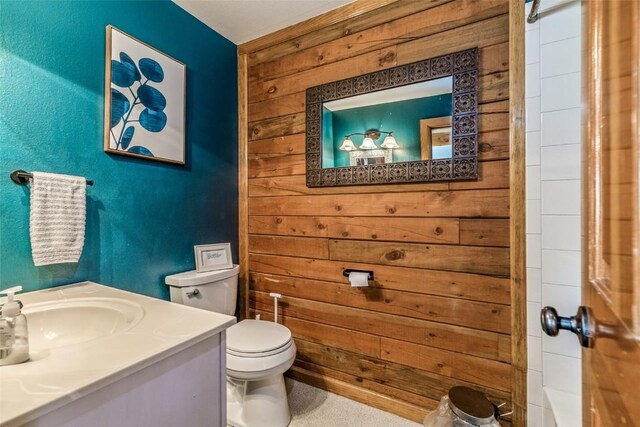 full bath with vanity, wooden walls, toilet, and a tub