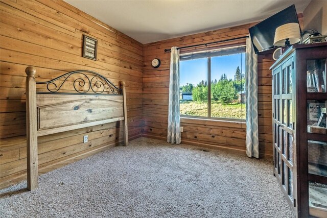 unfurnished bedroom featuring carpet floors and wooden walls