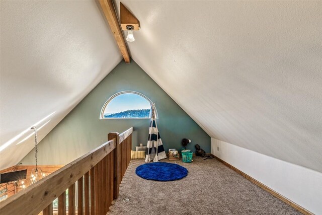 interior space with lofted ceiling with beams, baseboards, carpet, and a textured ceiling