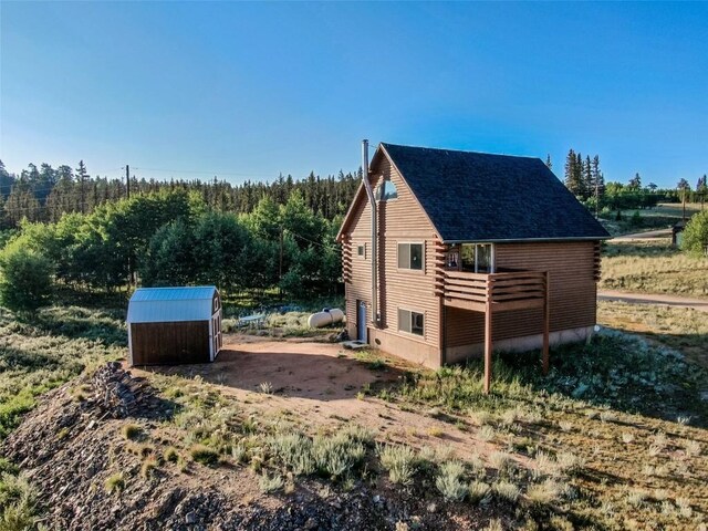 view of side of property featuring an outbuilding and log exterior