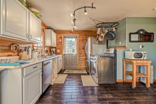 kitchen featuring a sink, dark wood finished floors, white cabinetry, stainless steel appliances, and light countertops