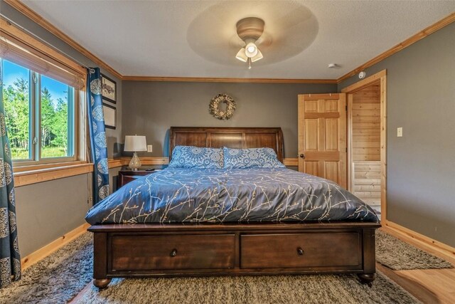 bedroom with ceiling fan, baseboards, ornamental molding, and wood finished floors