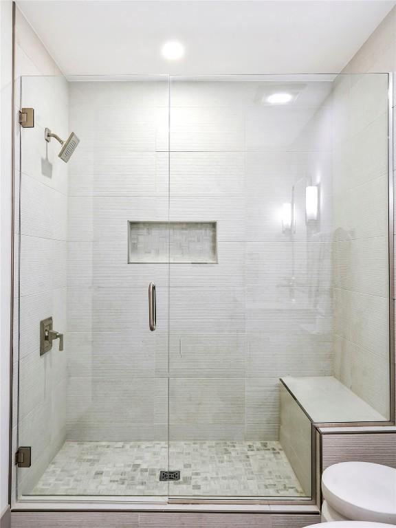 bathroom with toilet and a shower with shower door