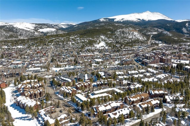 snowy aerial view with a mountain view and a residential view