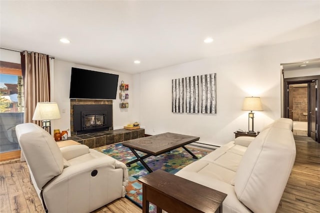 living area with recessed lighting, wood finished floors, and a fireplace