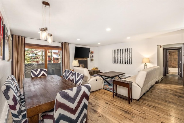 dining area with recessed lighting, light wood-type flooring, and a fireplace