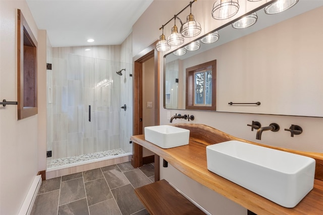 bathroom featuring vanity, a baseboard heating unit, and a shower with door