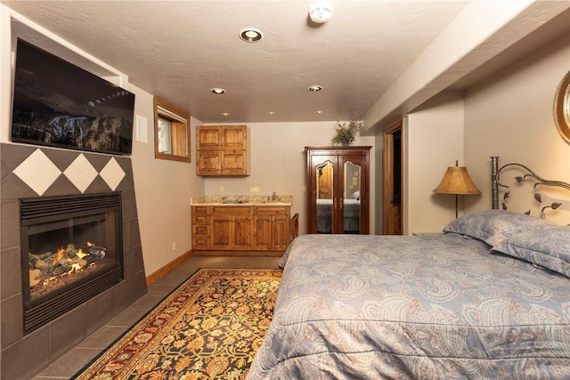 tiled bedroom with recessed lighting, baseboards, and a tile fireplace