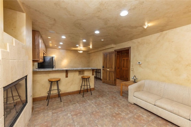 living room featuring recessed lighting, a fireplace, and baseboards