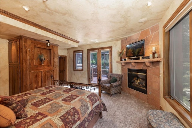 carpeted bedroom featuring french doors, access to exterior, and a fireplace