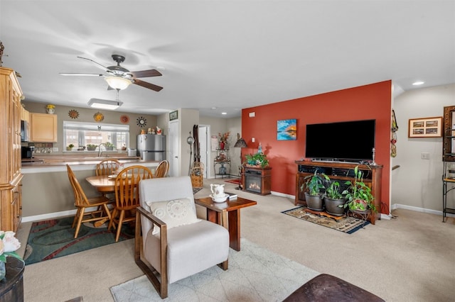 carpeted living room featuring ceiling fan and sink