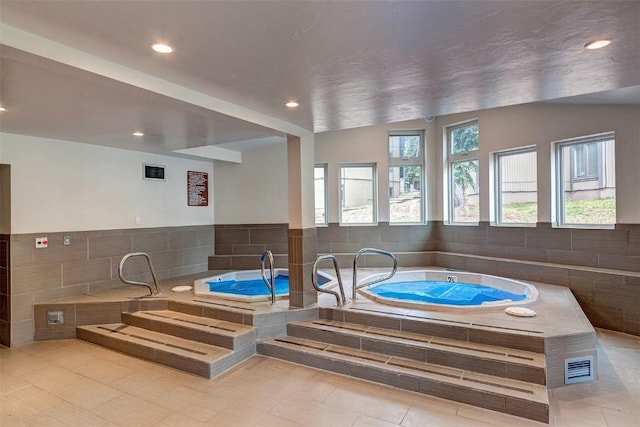 view of swimming pool featuring an indoor hot tub