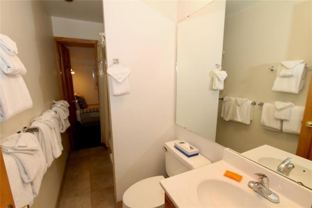 bathroom with tile patterned flooring, vanity, and toilet