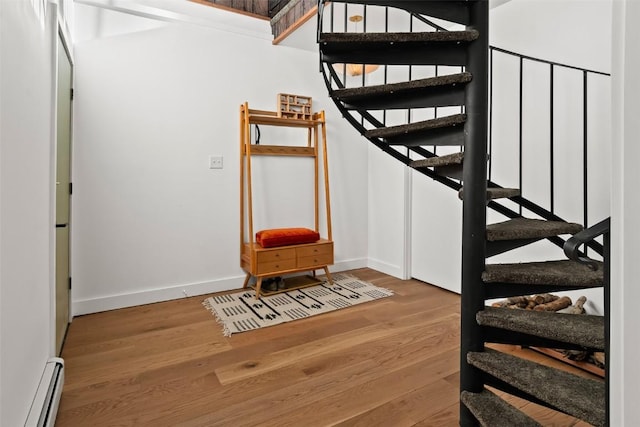 stairway featuring hardwood / wood-style floors and a baseboard radiator