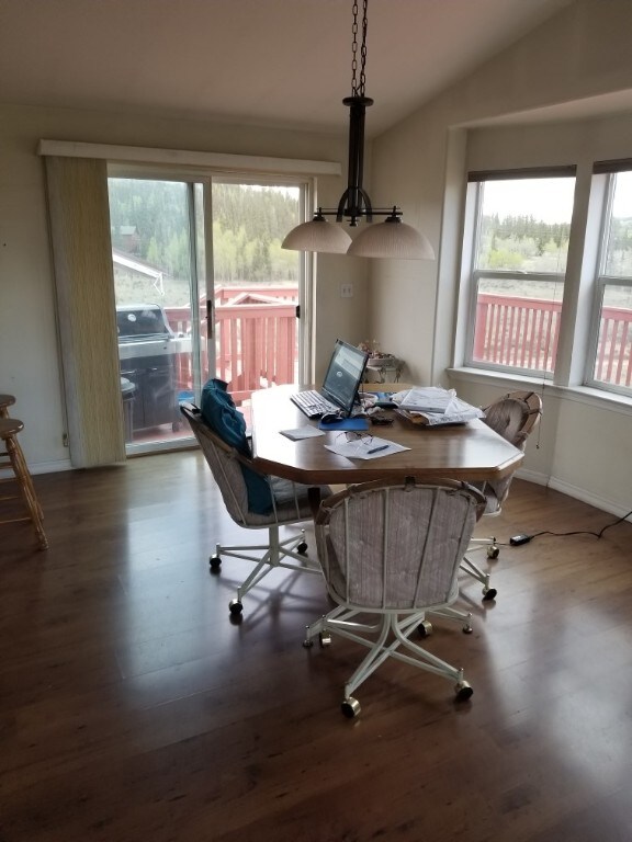 dining room with wood-type flooring and vaulted ceiling